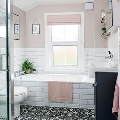 a bathroom with a tub, toilet and sink in it's center window is shown