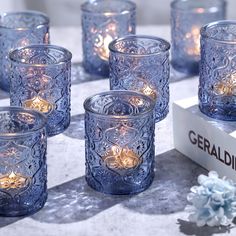 several blue glass candles sitting on top of a table