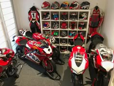 a room filled with lots of red and white motorbikes in front of shelves