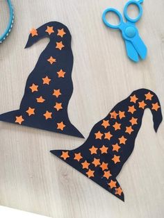 paper cut out of the shape of a witch's hat with orange stars on it