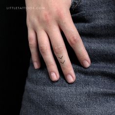 a woman's hand with a small tattoo on it