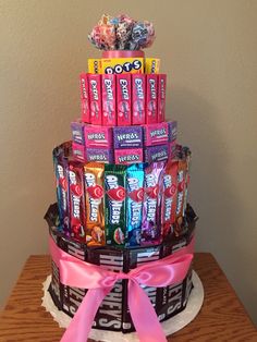 a cake made to look like a stack of candy bars with pink ribbon on top