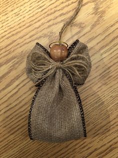 an ornament hanging from a string on top of a wooden table with a bow