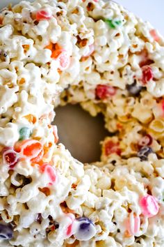 a close up of a cake with marshmallows on it and the words, popcorn & candy marshmallow cake