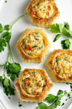 three mini quiche cakes on a white plate with parsley