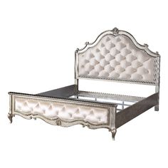 an antique style bed with white upholstered headboard and foot board, made from wood