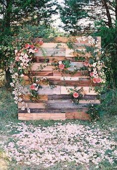 an old pallet with flowers and greenery on it is sitting in the grass