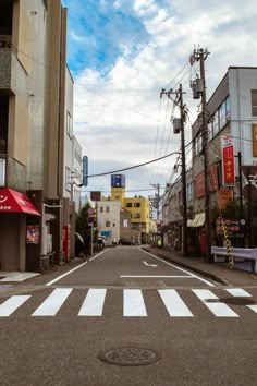 an empty street with buildings and signs in the background