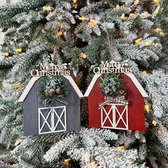 two red and gray barns with christmas decorations hanging from them on a tree in the snow