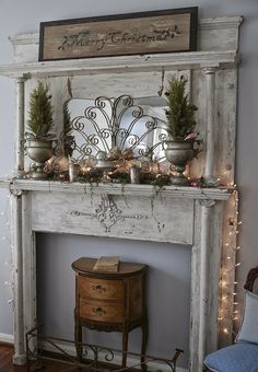 an old fireplace decorated for christmas with potted plants and greenery on the mantel