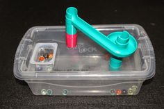 a plastic container filled with beads and a blue pipe