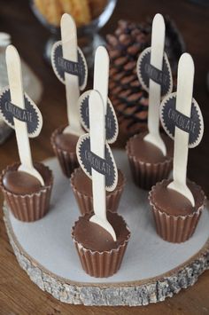 there are chocolates with spoons in them on the plate and one has a name tag