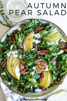 a bowl filled with apples and other vegetables on top of a white table cloth next to a