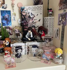 many anime figurines are sitting on top of a shelf in a room with posters and other items