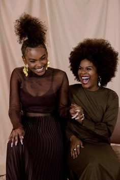 two women sitting next to each other smiling