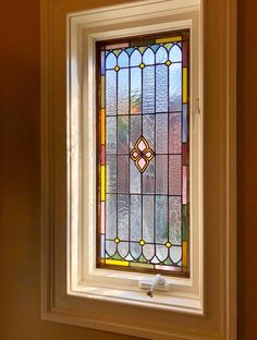 a bathroom with a toilet and a stained glass window