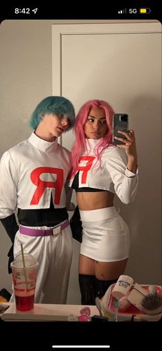 two people dressed up in costumes taking a selfie with a cell phone while standing next to each other