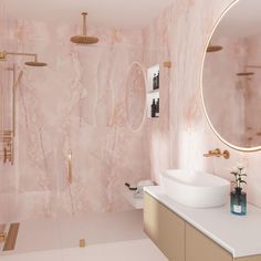 a bathroom with pink marble walls and floor, gold faucet, round mirror, sink, shower head, and bathtub