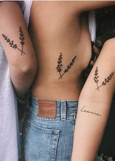 two people with tattoos on their stomachs, one is holding the other's back