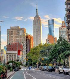 a city street with tall buildings in the background