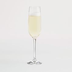 a glass filled with white wine on top of a table