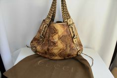 Gucci Pelham Medium Python Bag. RARE Gorgeous Color Metallic Gold Braided Leather Straps with Gold Bit Hardware On This Beautiful Brown/Tan/Gold Python Hobo Bag. Perfect Medium Size: 17” length x 12” height x 5” width. Top Open Access with Strap Loop Snap. Inside Sued Lining and Large Zip Pocket. Gold Stud Feet. Gucci Dust Cover Included. Gucci Signature Logo and Authentication Numbers.  Photos Are Actual Of This Bag. Some Minimal Normal Wear (see photos). Bag is in Great Condition. Smoke/Pet Fr Gucci Satchel Shoulder Bag With Handles, Gucci Satchel Shoulder Bag, Gucci Shoulder Bag With Double Handle And Removable Pouch, Gucci Beige Bag With Top Carry Handle, Gucci Shoulder Bag With Top Carry Handle, Gucci Brown Satchel Bag, Beige Gucci Bag With Top Carry Handle, Gucci Beige Double Handle Bag, Gucci Beige Bag With Removable Pouch