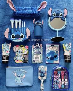 various items are displayed on a blue towel and include toothbrushes, makeup bag, eyeliners, lipstick, mirror, etc