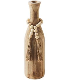 a wooden vase with tassels and beads