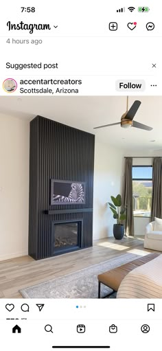 a living room with a fire place in the center and a ceiling fan above it