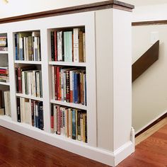 the bookshelf is built into the wall by the stairs