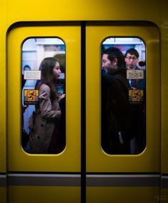 two people standing in front of a yellow door