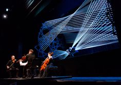 three men are playing instruments on stage