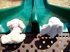 two stuffed animals sitting on top of a slide