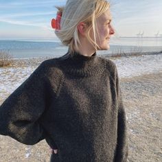 a woman with blonde hair standing on the beach