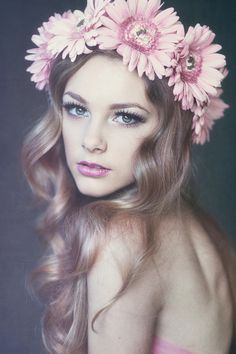 a woman with flowers in her hair is posing for a black and white photo,