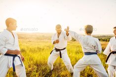 group of men practicing martial moves in the field at sunset with sun shining on them