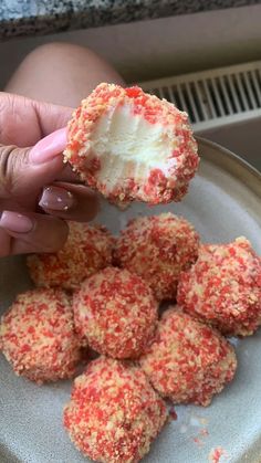 a person is holding up some food on a plate and it looks like they are covered in red sprinkles