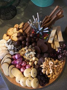 a wooden platter filled with lots of different types of cookies and candies on top of it