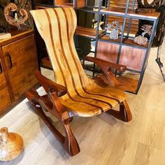 a wooden rocking chair sitting on top of a hard wood floor next to a cabinet