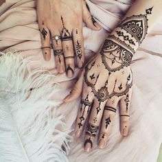 two hands with henna tattoos on them