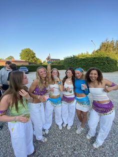 several women in white and blue outfits posing for a photo with one woman holding her hand up