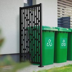 three green trash cans in front of a building