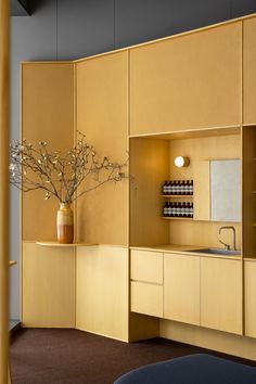 a vase with some flowers in it sitting on a shelf next to a sink and cabinets