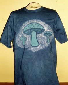 a blue t - shirt with green mushrooms on it