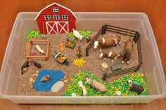 a plastic container filled with lots of toys and animals on top of a wooden floor