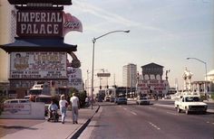 an old photo of people walking on the sidewalk