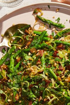 a white plate topped with asparagus and other food on top of a table