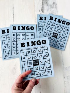 three blue and black printable numbers are being held up by someone's hand