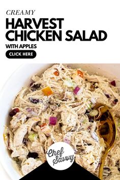 chicken salad with apples and cranberries in a white bowl next to a spoon