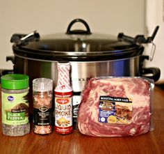 meat, spices and seasonings are sitting in front of an open slow cooker